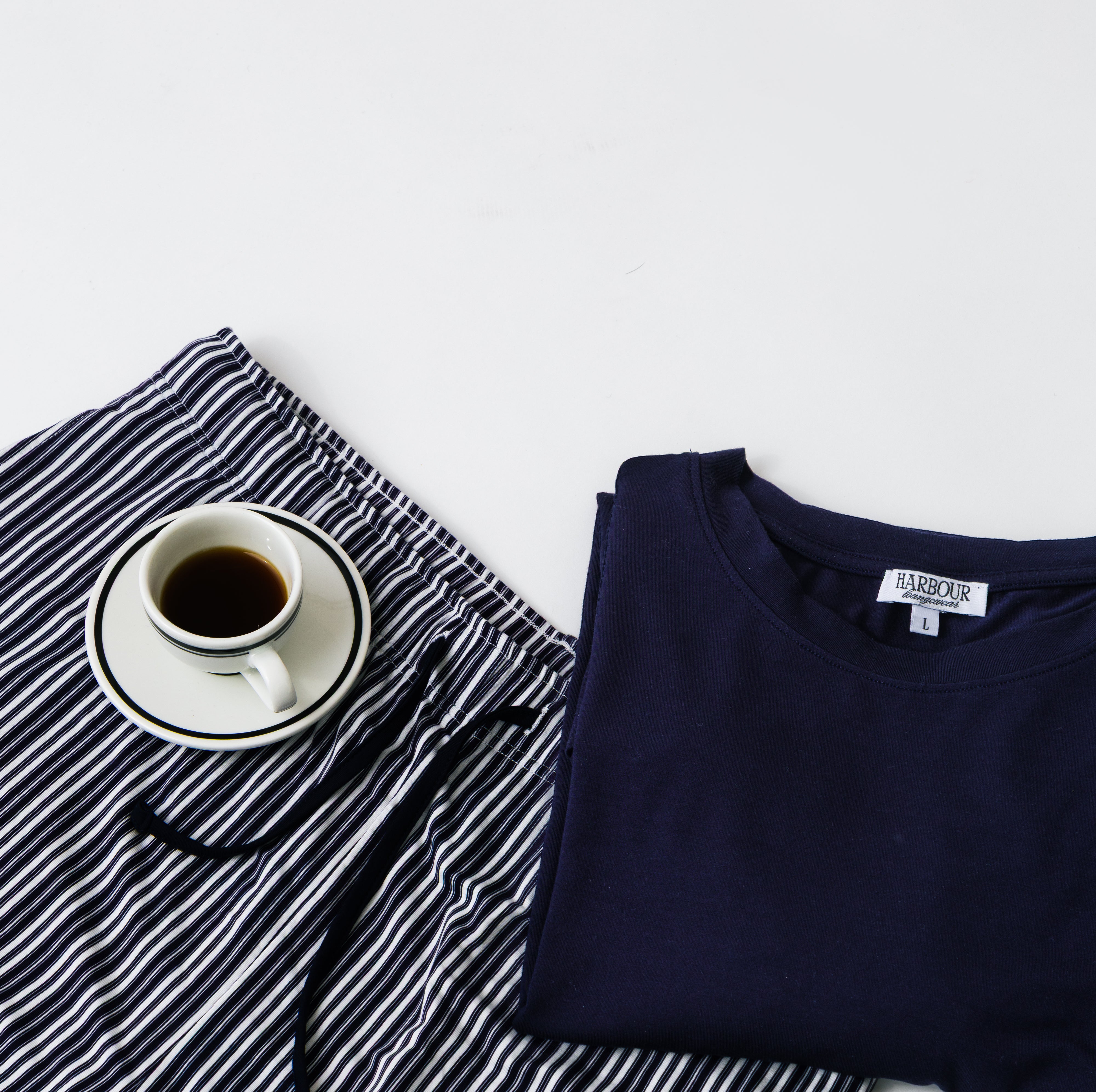 Harbour navy modal T-shirt and striped shorts with coffee cup – relaxed men’s loungewear flat lay